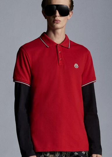 Ce polo pour homme, en piqué pur coton, combine lignes polyvalentes et détails graphiques qui rappellent l’héritage de la marque.