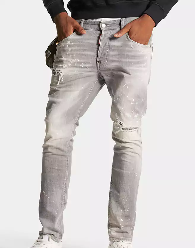 Pantalon en denim stretch cinq poches. Délavage : used avec marques d'usure, déchirures et taches all-over.