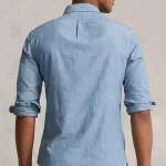 La chemise Ralph Lauren en coton teint à l'indigo affiche une coupe près du corps, tandis que son tissu léger