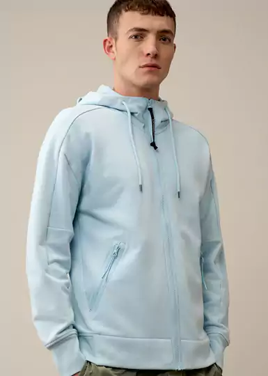 Ce sweatshirt CP Company à capuche pour homme présente une fermeture zippée sur toute la longueur, des poches sécurisées en biais pour les mains et la célèbre capuche Goggle Hood de C.P. Company
