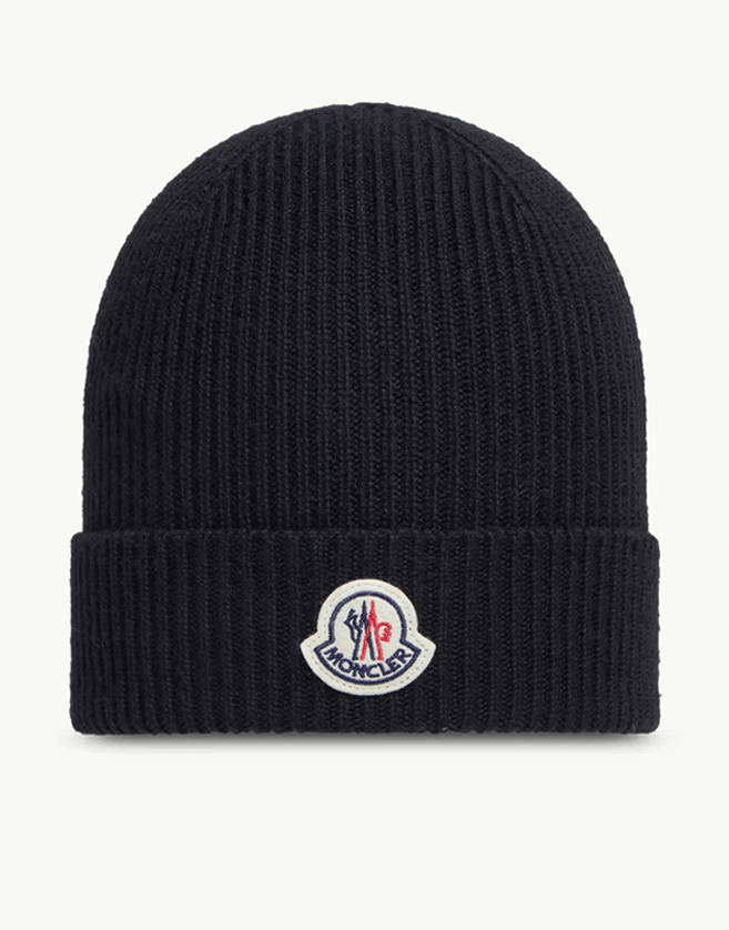 Ce bonnet Moncler en maille côtelée pour homme apporte chaleur et protection.