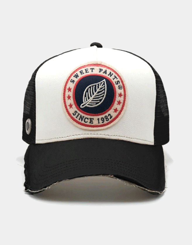 Casquette Sweet Pants trucker en bi-matière et bicolore. Patch logo Sweet Pants sur le devant avec tranche visière effet « destroy »